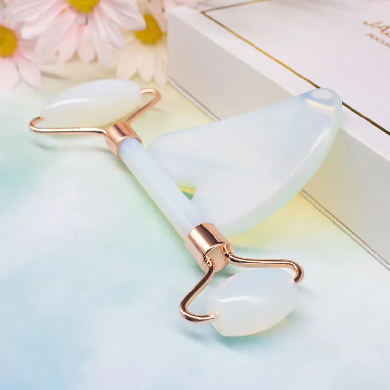 Aventurine face roller with opal heart design on a flat surface