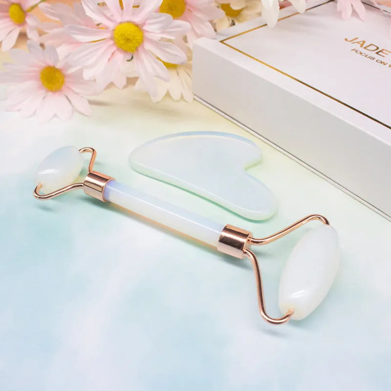Aventurine face roller with opal heart design on a flat surface