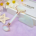 Aventurine face roller with opal heart design on a flat surface