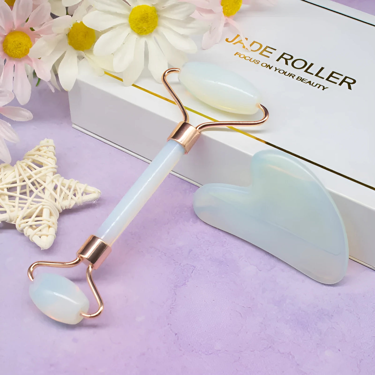 Aventurine face roller with opal heart design on a flat surface