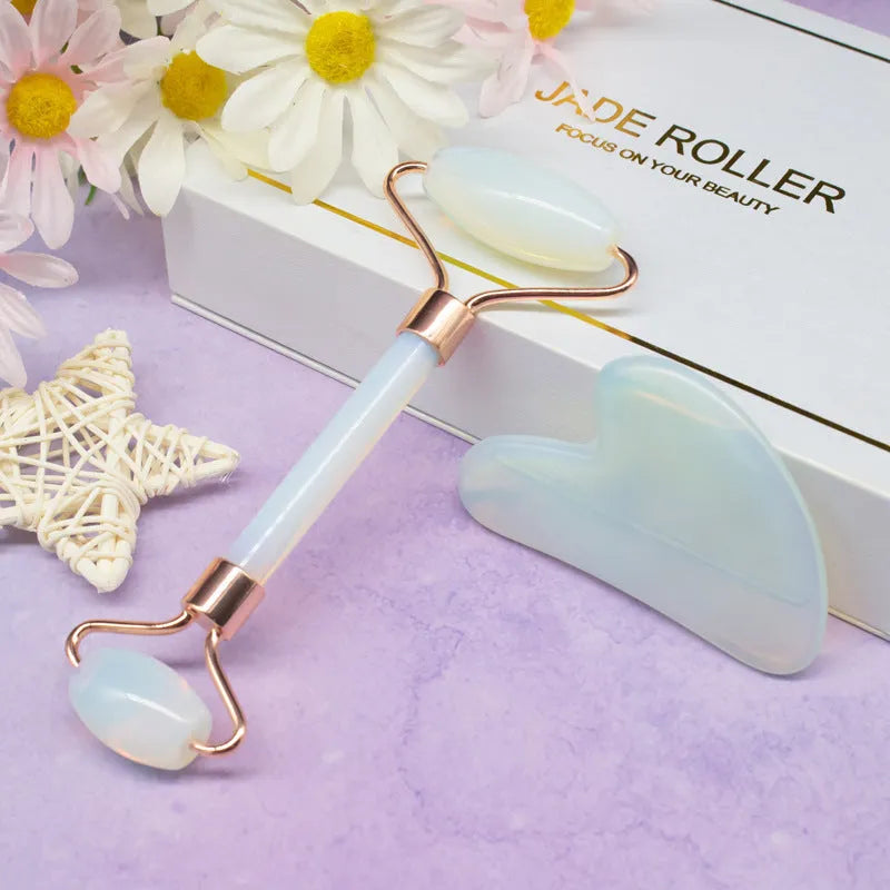 Aventurine face roller with opal heart design on a flat surface