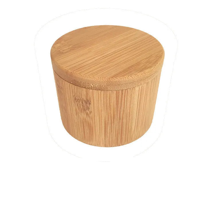 Bamboo seasoning storage box with a small bamboo spoon on a kitchen counter.