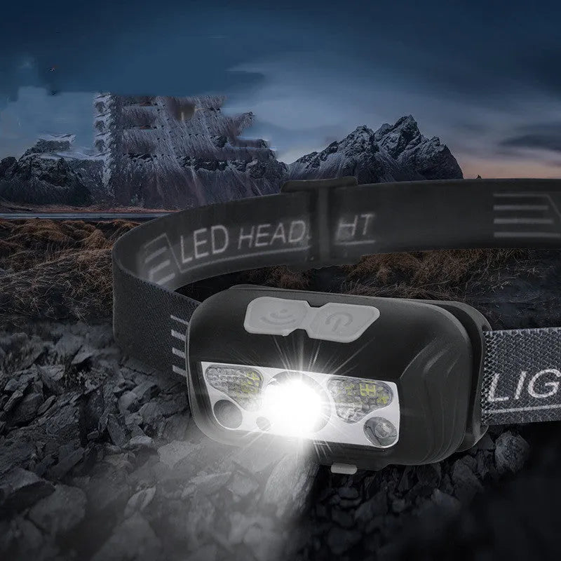 Black USB rechargeable sensor headlight with red LED safety light on adjustable strap.