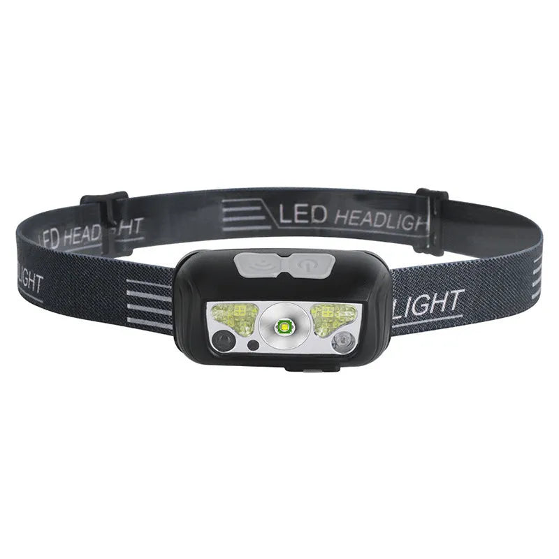 Black USB rechargeable sensor headlight with red LED safety light on adjustable strap.