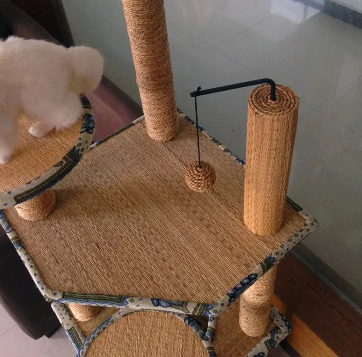 Cat playing on a natural wheat straw scratch board climbing frame with multiple levels