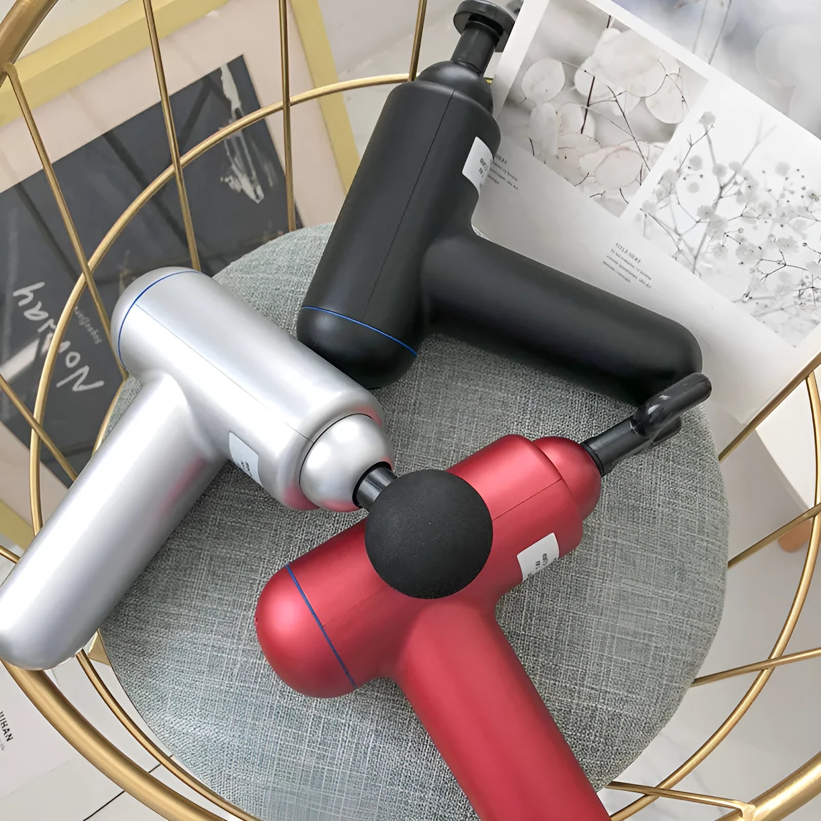 Black handheld fascia gun muscle massager on a grey background