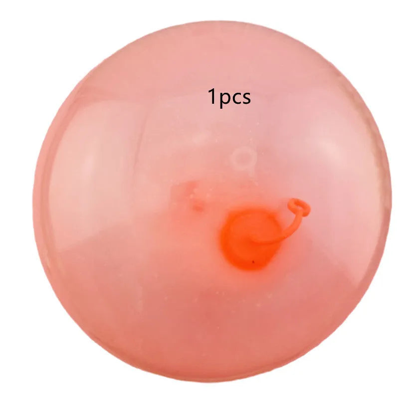 Large pink TPR inflatable bouncy ball for children's outdoor play, shown with a pump