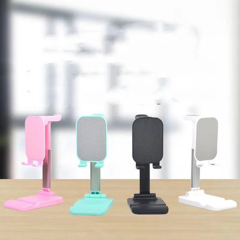 Folding mobile phone stand on a desk holding a smartphone, available in black green pink and white colours