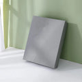 Large blue rectangular cardboard gift box with white base and bow on a plain background