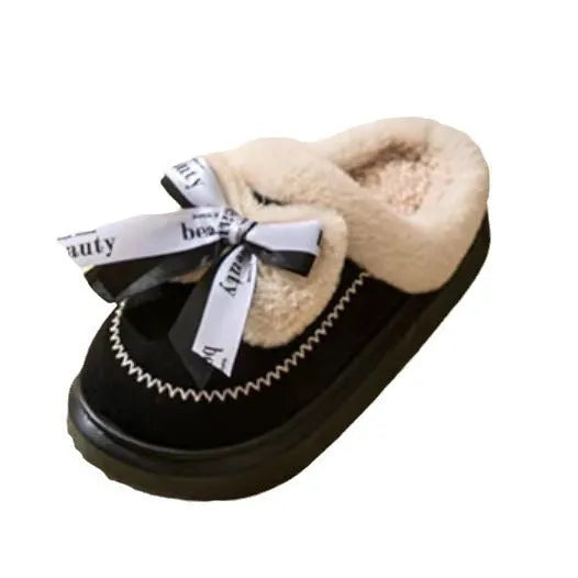 Beige women's suede half slippers with a black ribbon bow and thick cotton sole.