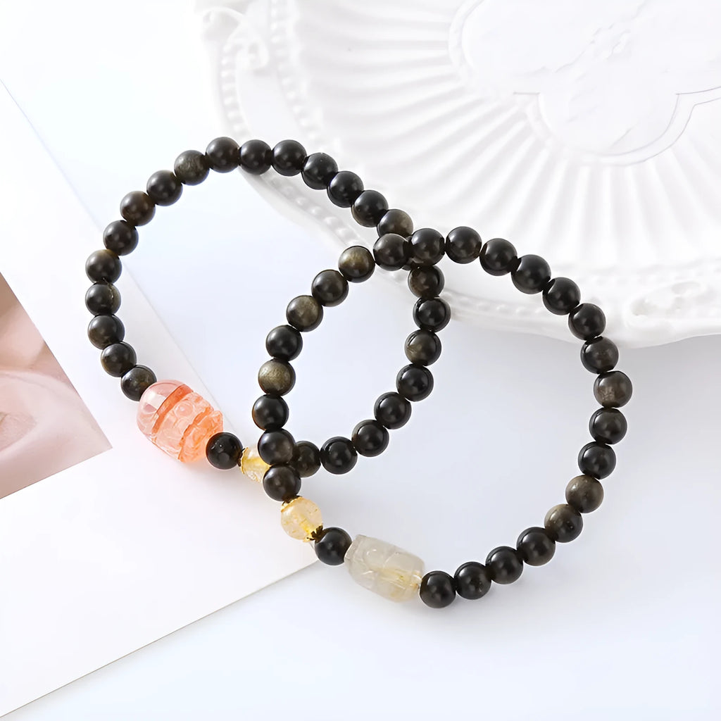 Handcrafted natural obsidian Pi Xiu bracelet in gold obsidian and red flower colours on wrist