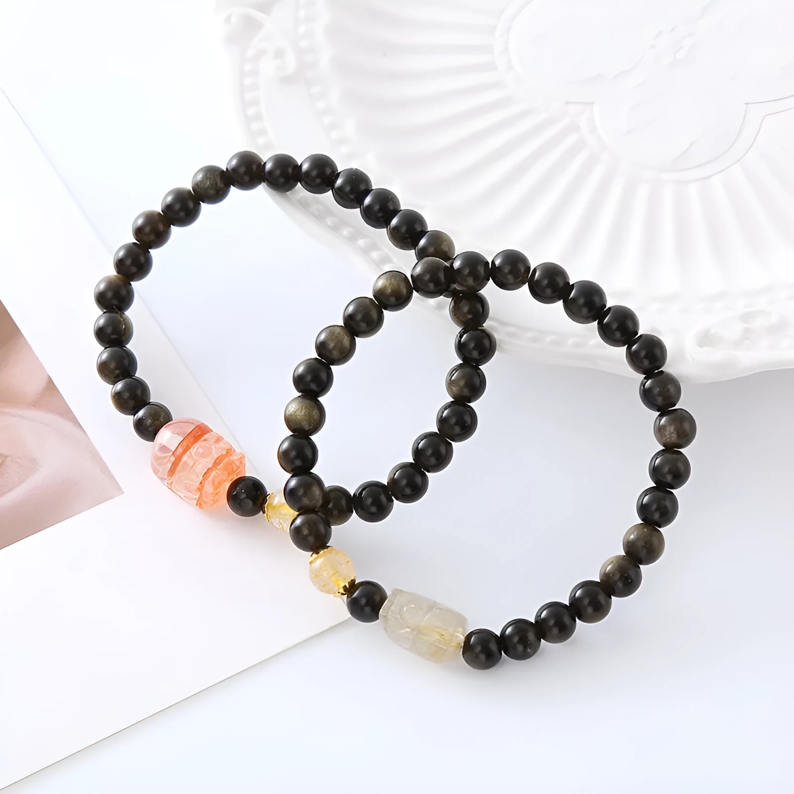 Handcrafted natural obsidian Pi Xiu bracelet in gold obsidian and red flower colours on wrist