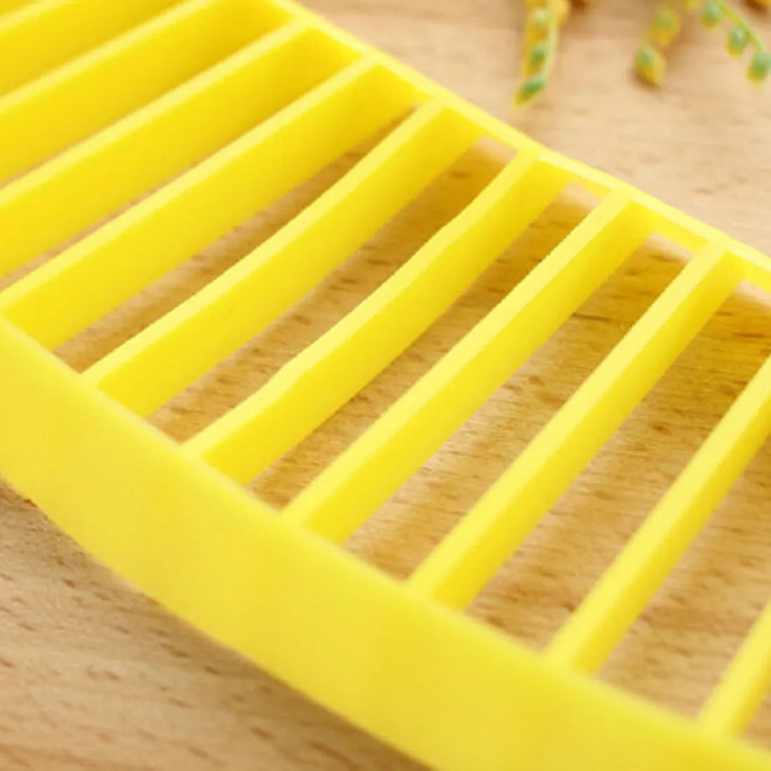 Yellow banana slicer made from food-grade PP plastic on a light background