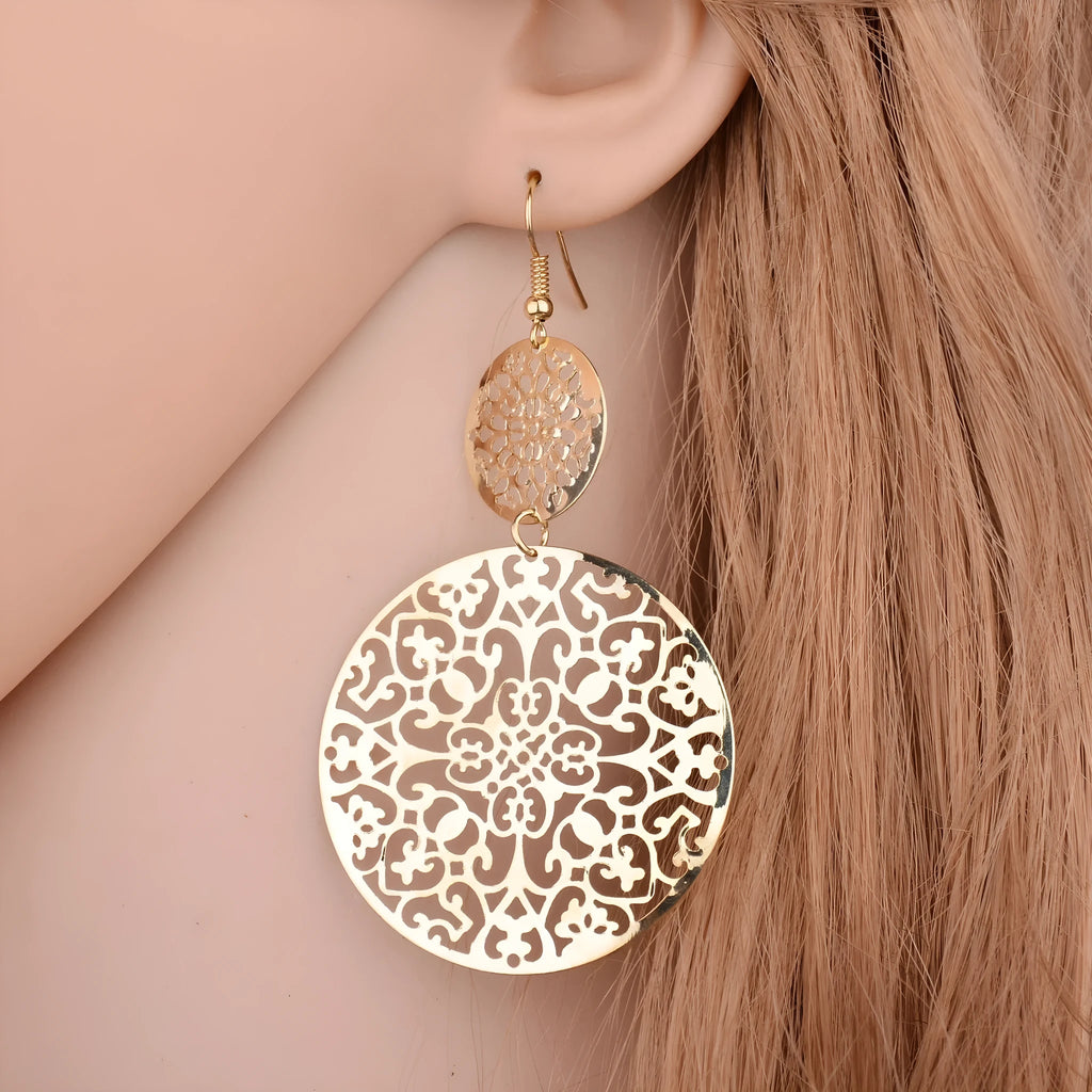 Women's round hollow gold drop earrings with dangle design on a light background
