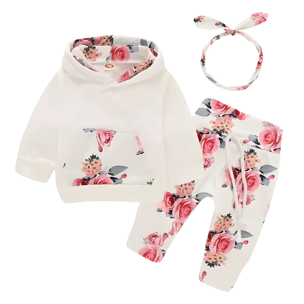 White cotton hooded pantsuit for a baby girl on a hanger, showing long sleeves and full-length trousers.