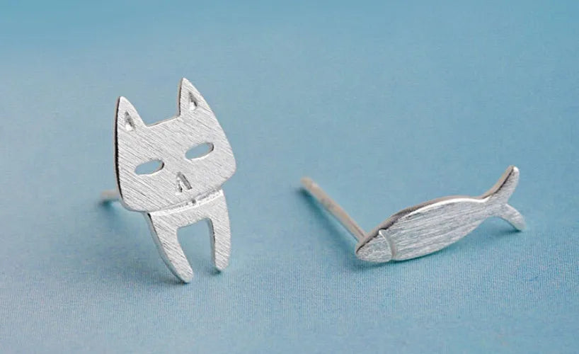 S925 sterling silver stud earrings with asymmetrical cat and fish design on white background
