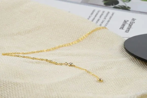 Gold colour alloy geometric pendant necklace with snake bone chain on display