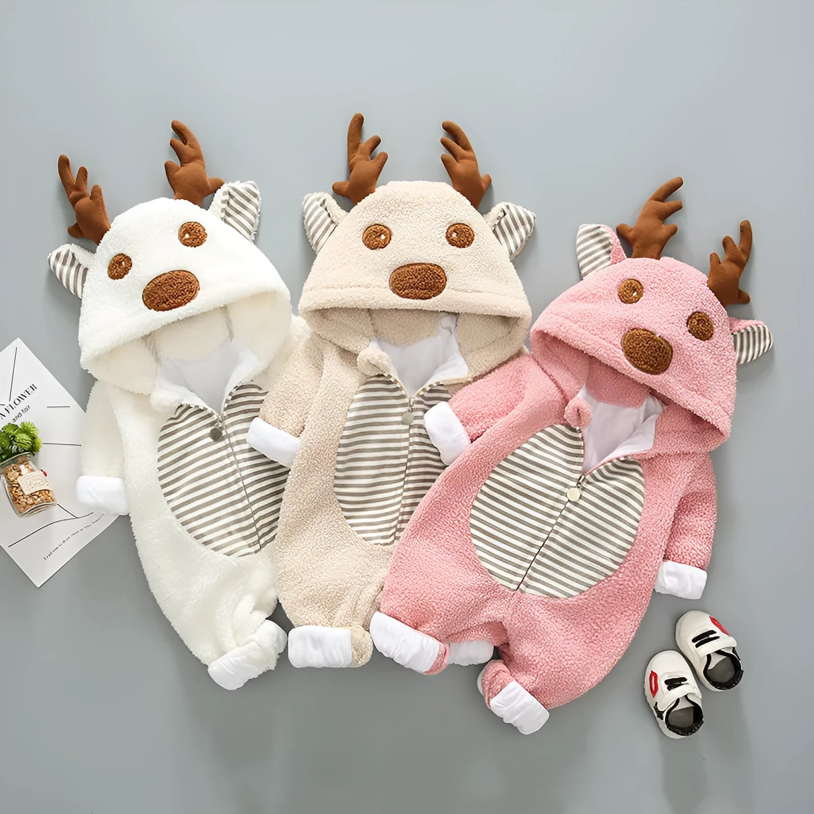 Long-sleeved baby romper with front lace-up strap closure in a khaki colour.