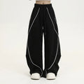 Black striped pleated wide-leg hip hop trousers laid flat, showing loose fit and mid waist.