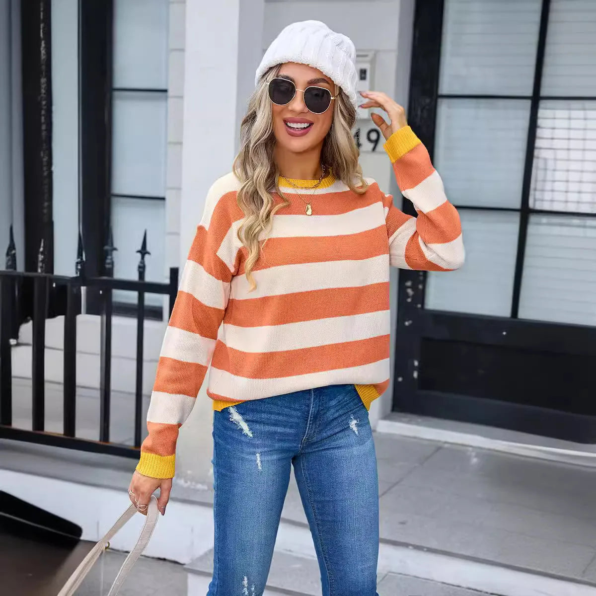 Women's loose blue striped acrylic knit sweater with long sleeves on a hanger.