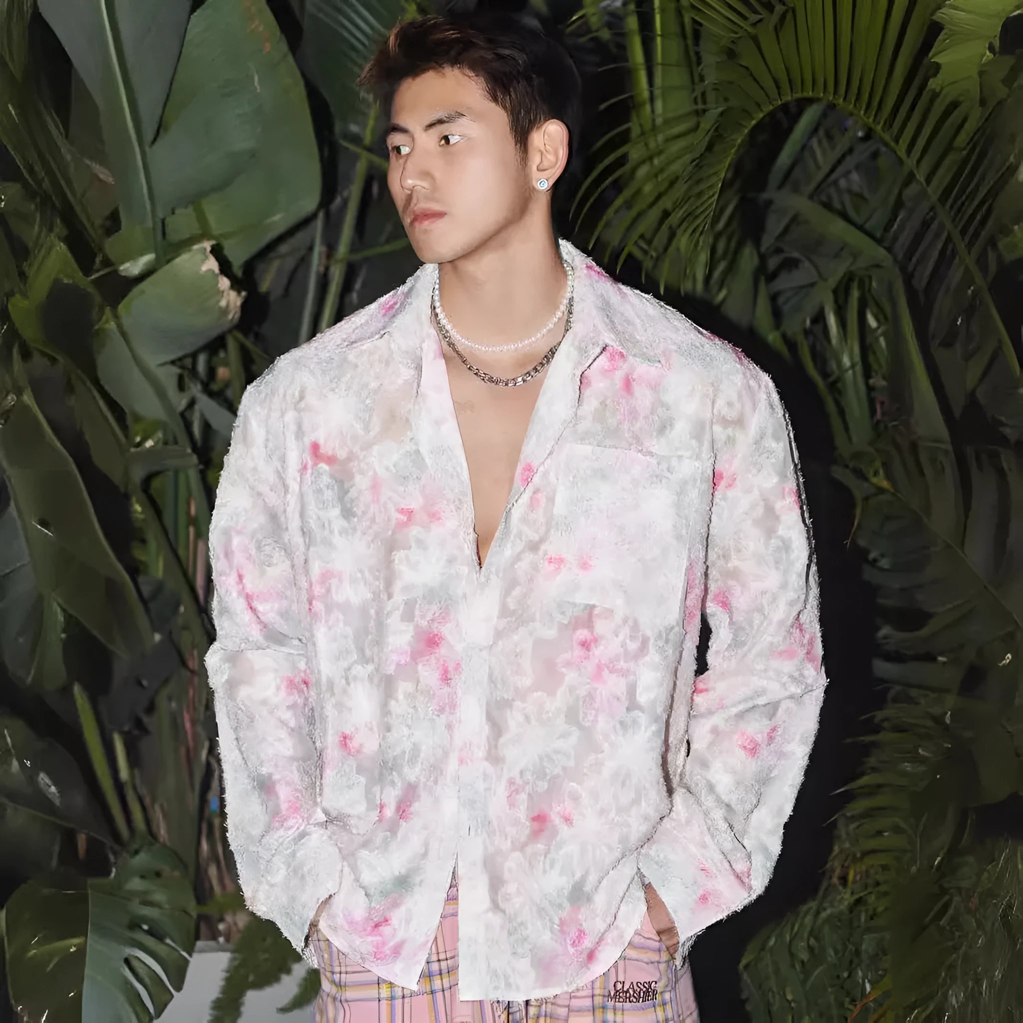 Pink embossed floral pattern long sleeve shirt laid flat, showing loose fit and textured design.