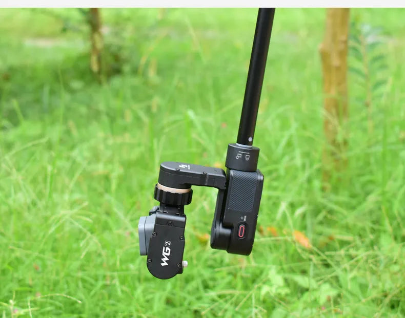 Black retractable aluminium selfie stick with phone clamp, extended to full length.