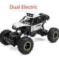 Black and silver remote control off-road car on rough terrain showing four-wheel drive and climbing capability.