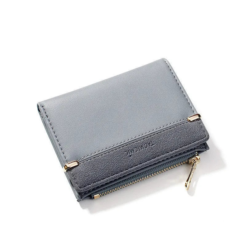 Black ladies bi-fold wallet with a gold zipper, open to show multiple card slots and a coin compartment.