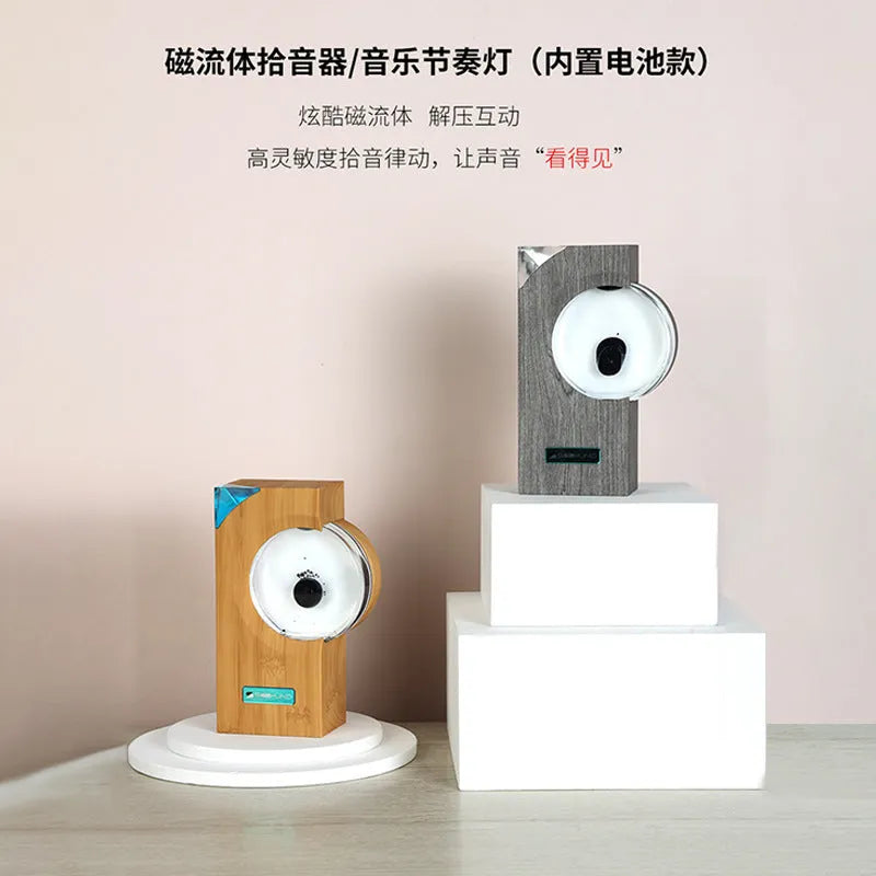 Dancing ferrofluid speaker in gray plastic casing with warm white light showing magnetic fluid shapes