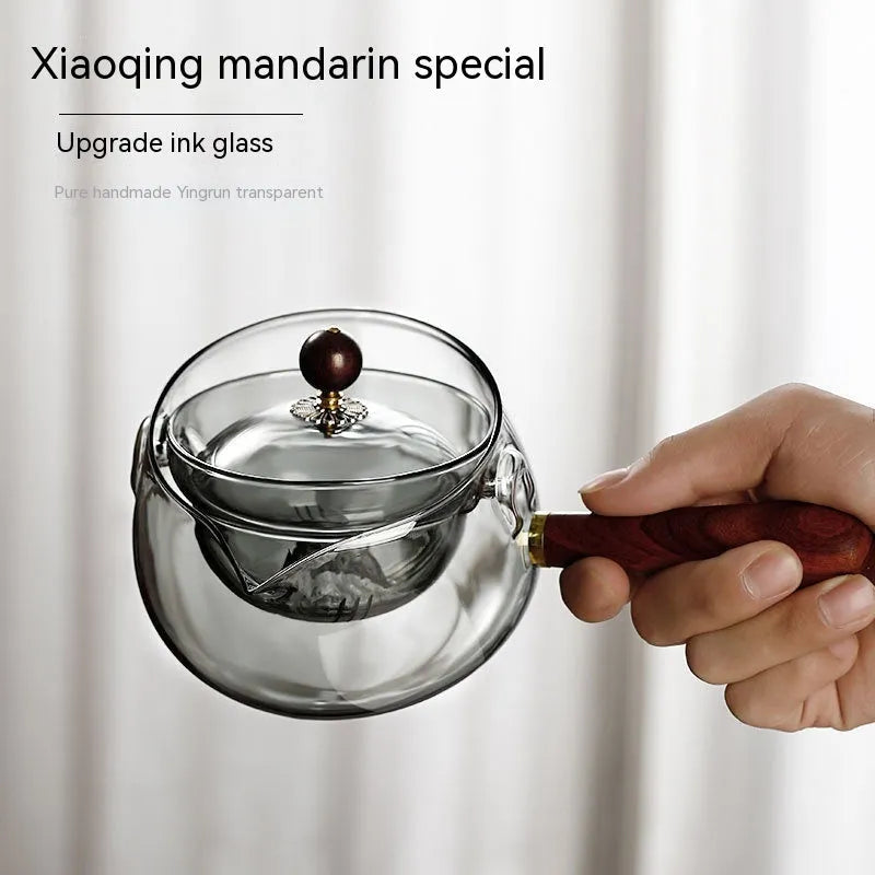 Transparent rotating glass teapot with wooden handle and integrated tea infuser