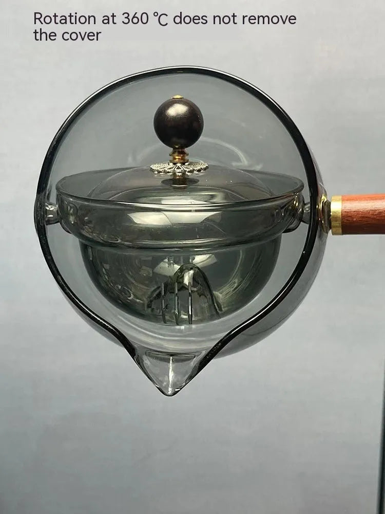 Transparent rotating glass teapot with wooden handle and integrated tea infuser