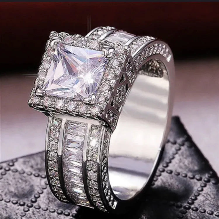 Geometric silver-toned women's ring with a round design element on a hand.
