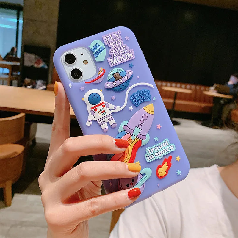 Purple silicone iPhone case with a cartoon astronaut graphic, showing front and back views.