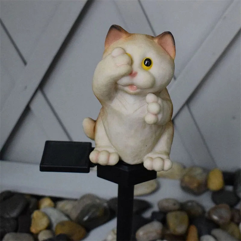 Brown cat-shaped resin solar light standing in a garden