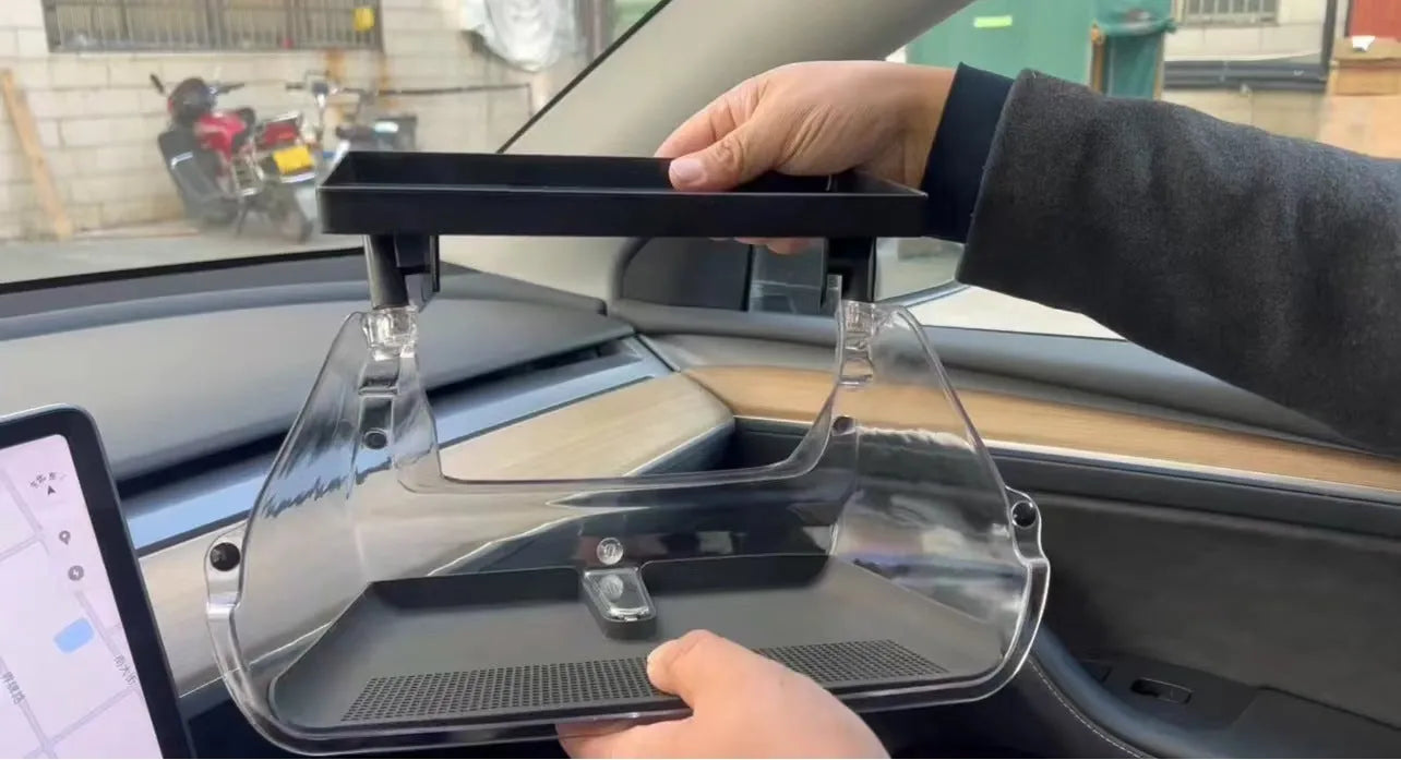 Black ABS plastic storage box fitted under the touchscreen of a Tesla Model Y interior.