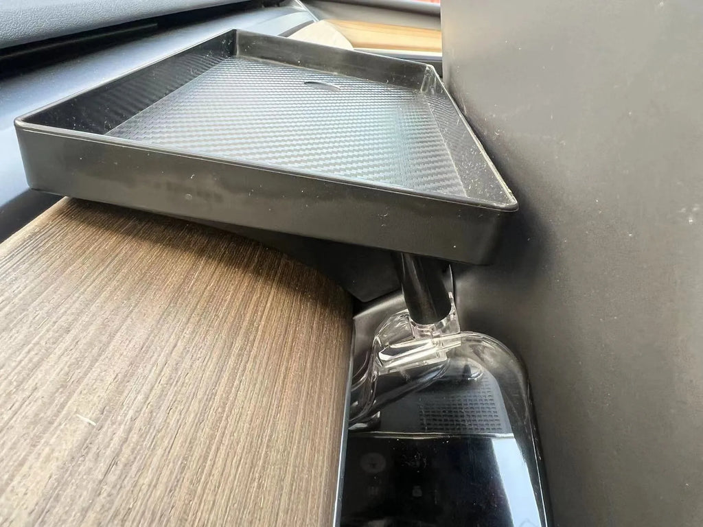 Black ABS plastic storage box fitted under the touchscreen of a Tesla Model Y interior.
