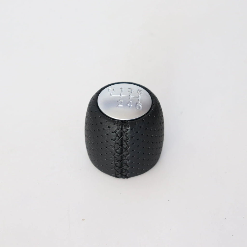 Sewn wrapped perforated leather gear knob for Alpha car in black, red, or white with matte or silver cover.