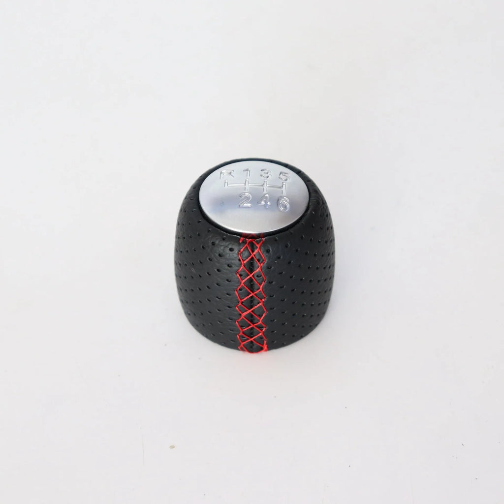 Sewn wrapped perforated leather gear knob for Alpha car in black, red, or white with matte or silver cover.