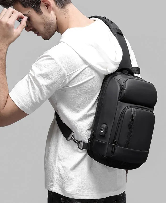Black PVC outdoor leisure shoulder bag with a single strap, showing dedicated pockets for ID, phone, and computer.