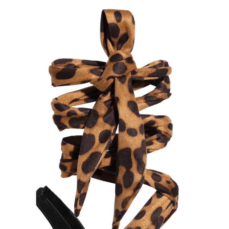 Light brown leopard print women's high heels with cross straps and a fine super high heel.