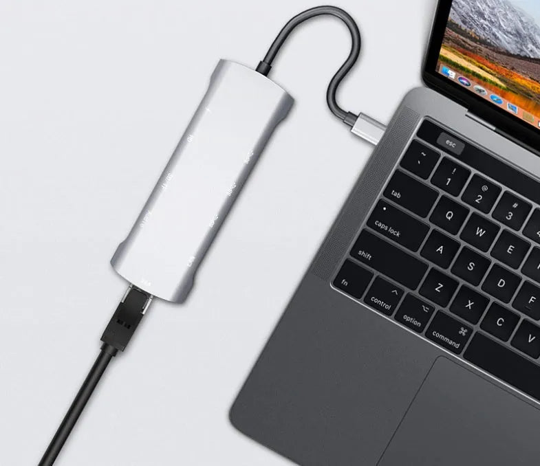 Grey aluminium USB-C docking station showing HDMI, VGA, USB 3.0, and card reader ports.