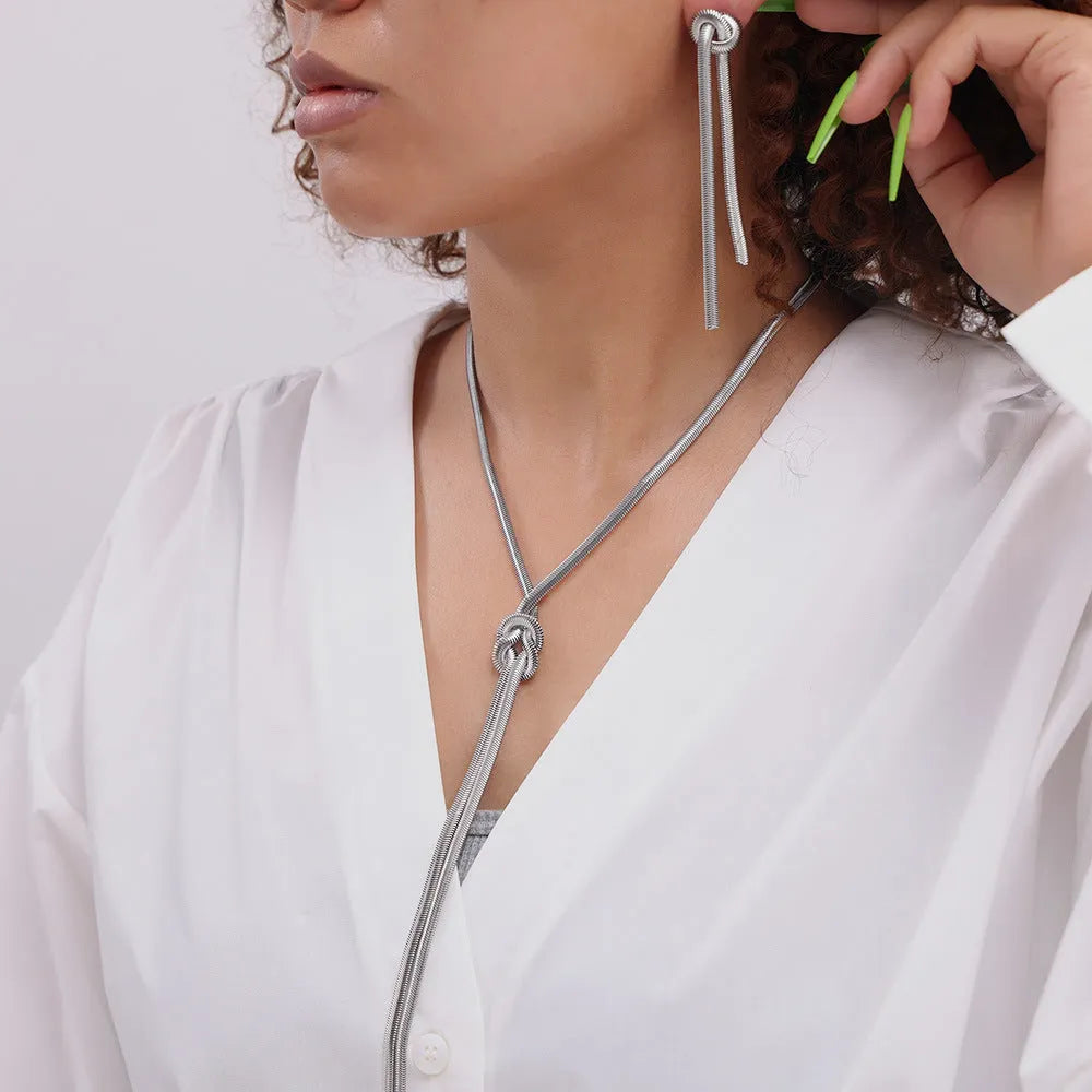 Gold electroplated titanium steel necklace with knotted tassel pendant on snake chain and matching earrings
