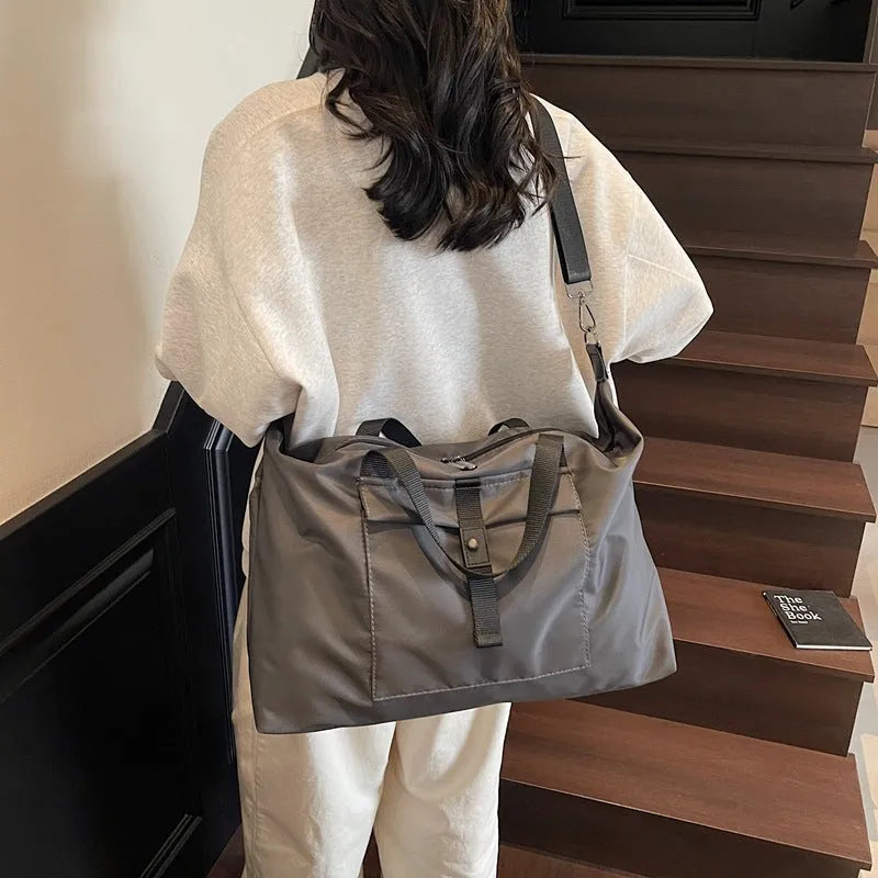 Grey one-shoulder travel bag made from Oxford cloth with a large capacity.