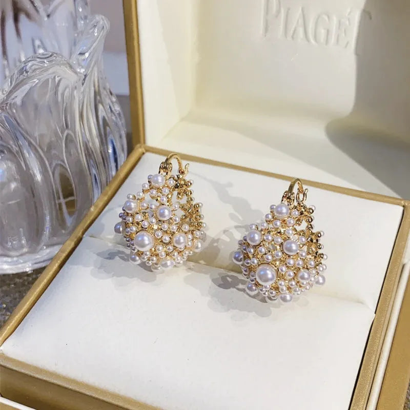 Gold-coloured copper flower basket earrings with small rice-shaped beads and pearl inlay detailing.