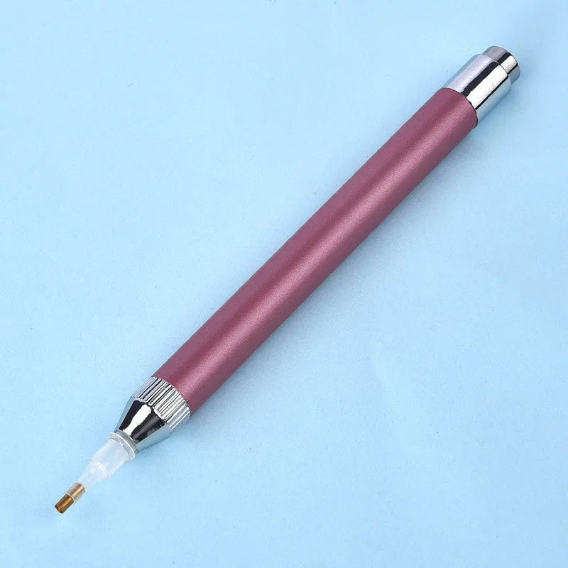 Blue luminous aluminium alloy drill pen for diamond painting and cross stitch crafts on a dark surface.