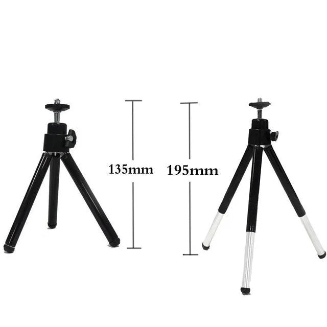 Compact mini desktop tripod with extendable aluminium legs and a black U-shaped phone clip attached.