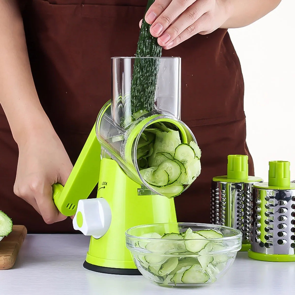 Round vegetable mandoline slicer with stainless steel blades and suction base in green colour