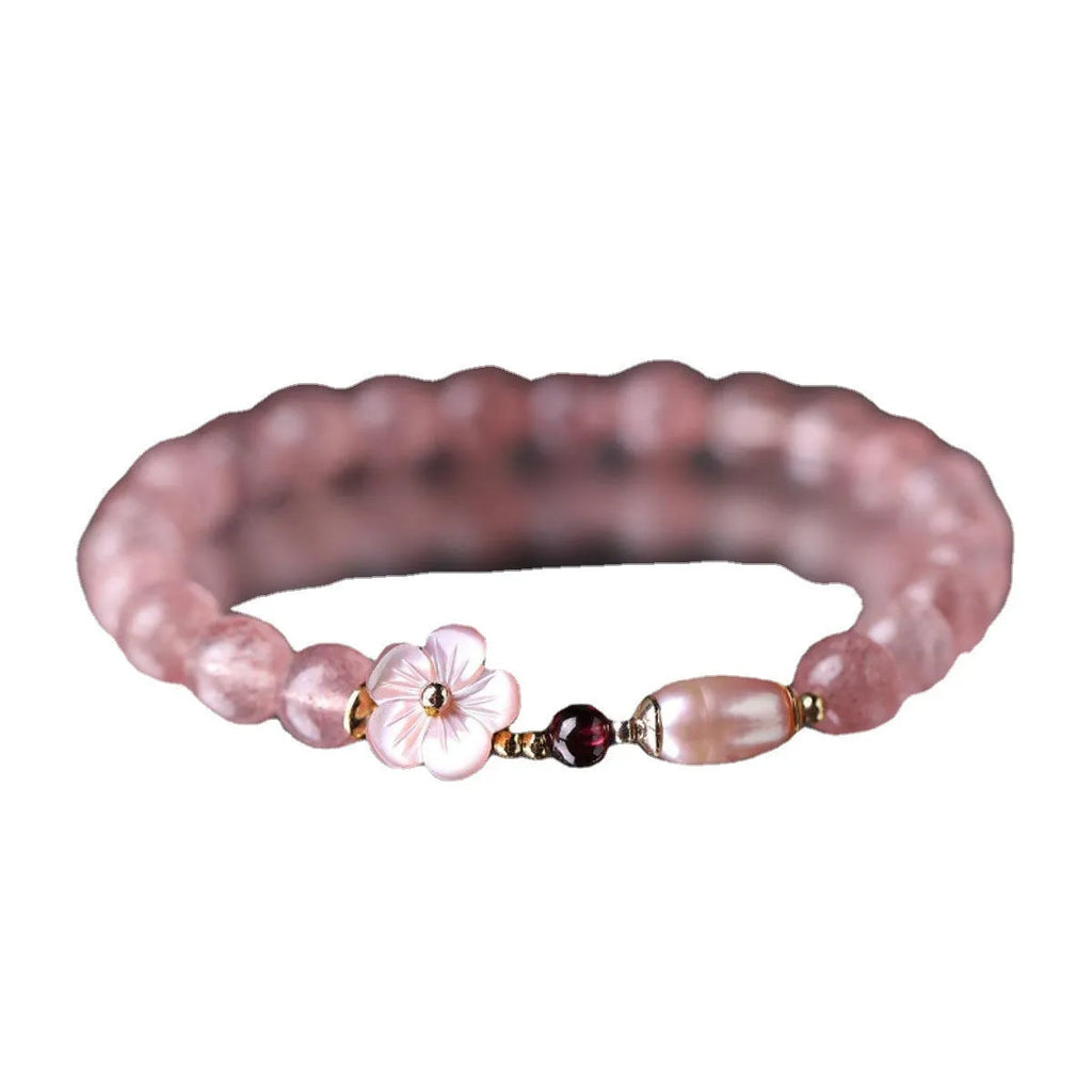 Women's strawberry quartz crystal bracelet with peach blossom flower bead design on wrist