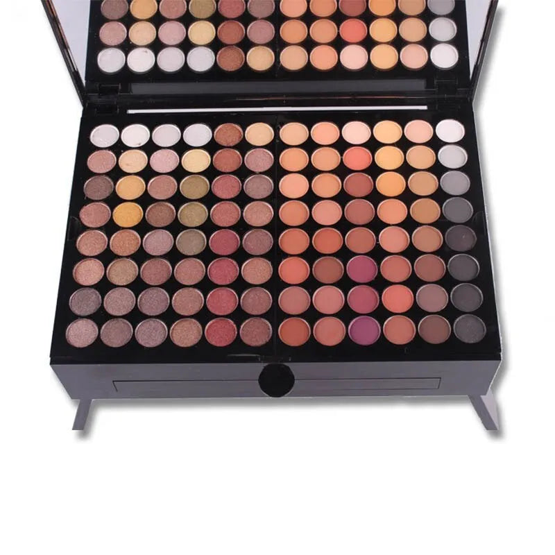 Piano-shaped makeup palette open to show 180 eyeshadows, blushes and powders inside.