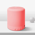 A11 compact wireless subwoofer speaker in black, pink, blue, or green colour on a desk.